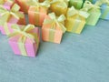 Gift boxes with rainbow light gradient colors are neatly arranged on a blue-green watercolor textured background, copy space. Royalty Free Stock Photo