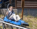 Fifteen year-old girl having fun in a blue sled on a rollercoaster-like track in Vail, Colorado.