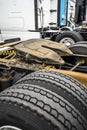 Fifth wheel truck coupling and rear suspension and wheels of big rigs semi trucks standing in row on the parking lot Royalty Free Stock Photo