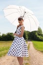 Fifties look with petticoat dress, hairband and sunshade in the