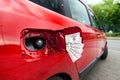 Fifty dollar bills sticking out of an open gas cap on a car Royalty Free Stock Photo