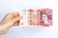 Fifty english pounds banknote in woman`s hand. Concept of paying taxes in the end of a year.