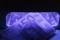 Fifty euro banknote check in infrared light. Real or fake money examination