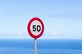Fifty traffic sign. 50 miles per hour speed limit sign round red against blue sky Royalty Free Stock Photo