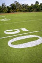 Fifty yard line on football field with goal post in distance Royalty Free Stock Photo