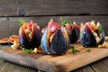 Fig appetizers with blue cheese, prosciutto and honey on a wood serving board