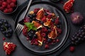 Fig, grape, raspberry and pomegranate salad on black plate