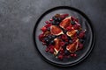 Fig, grape, raspberry and pomegranate salad on black plate