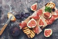 Fig with ham, cheese and toast. Prosciutto with figs on a rustic background. Top view, overhead, flat lay. Royalty Free Stock Photo