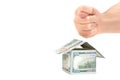 Fig hand gesture over a house made from dollar bills Royalty Free Stock Photo