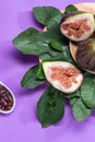 Fig jam with figs, fig leaves and white spoon with jam on purple background Royalty Free Stock Photo