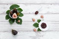 Fig jam with figs, fig leaves and white spoon with jam on White wood background Royalty Free Stock Photo