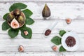 Fig jam with figs, fig leaves and white spoon with jam on White wood background Royalty Free Stock Photo