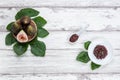 Fig jam with figs, fig leaves and white spoon with jam on White wood background Royalty Free Stock Photo