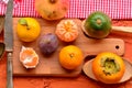 Fig, persimmon, pomegranate, avocado and mandarins (tangerines) on rough background. Still life theme. Royalty Free Stock Photo