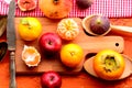 Fig, persimmon, pomegranate, avocado and mandarins (tangerines) on rough background. Still life theme. Royalty Free Stock Photo