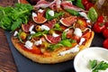 Fig pizza with bacon, green pimiento olives, rocket and basil leaves Royalty Free Stock Photo