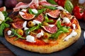 Fig pizza with bacon, green pimiento olives, rocket and basil leaves Royalty Free Stock Photo