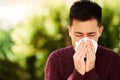 In the fight against flu. a young man blowing his nose outside. Royalty Free Stock Photo