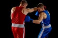 Fight. Dynamic portrait of two professional boxer in sports uniform boxing isolated on dark background. Concept of sport Royalty Free Stock Photo