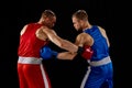 Fight. Dynamic portrait of two professional boxer in sports uniform boxing isolated on dark background. Concept of sport Royalty Free Stock Photo