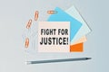 Fight for Justice - text on sticky note paper on gray background. Closeup of a personal agenda. Top view Royalty Free Stock Photo