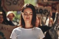 Fighting for clean planet. Young activist with word freedom written on her face keeping eyes closed while protesting