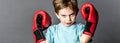 Fighting kid with freckles showing his boxing gloves up Royalty Free Stock Photo