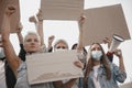 Group of activists giving slogans in a rally. Men and women marching together in a protest in the city.