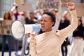 Fighting for the rights of others. a young woman shouting through a loudhailer at a protest.