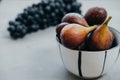 Figs in a bowl and dark grapes on a gray background. Autumn harvest Royalty Free Stock Photo