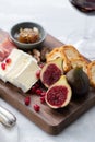 Figs with cheese and pomegranate on wooden board and red wine Royalty Free Stock Photo