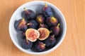 Figs fruits in a bowl on wooden background, top view Royalty Free Stock Photo