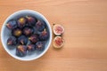 Figs fruits in a bowl on wooden background, top view Royalty Free Stock Photo