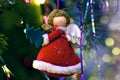 Figure of an angel with a Christmas tree in his hands, on a Christmas tree, new year`s background Royalty Free Stock Photo