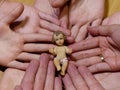Figure of baby jesus liyng on hands of a family and wedding ring Royalty Free Stock Photo