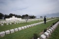 Figure in black reading gravestones, Gallipoli