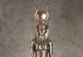 The figure of the Egyptian goddess Isis on a brown corduroy background. Bronze statuette