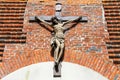 The figure of Jesus Christ crucified on the cross on the wall of an old Christian brick church. Sculpture symbol of Christ on the Royalty Free Stock Photo