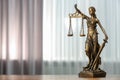 Figure of Lady Justice on table indoors, space for text. Symbol of fair treatment under law