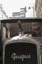 The figure of a lion on the hood of an old car.