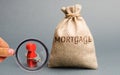 The figure of a man is handcuffed to a money bag with the word Mortgage. Impossibility of paying interest rates on mortgages and Royalty Free Stock Photo