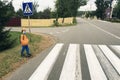 Figure of man, schoolboy in protective mask on sidewalk in front of pedestrian crossing on street. Concept of improving road Royalty Free Stock Photo