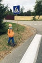 Figure of man, schoolboy in protective mask on sidewalk in front of pedestrian crossing on street. Concept of improving road Royalty Free Stock Photo