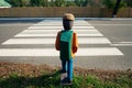 Figure of man, schoolboy in protective mask on sidewalk in front of pedestrian crossing on street. Concept of improving road Royalty Free Stock Photo