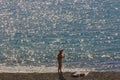 The figure of a man sunbathing on the beach,against the sea, shining in the sun Royalty Free Stock Photo