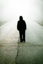 Figure of a man walking on a foggy road