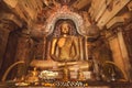 Figure of meditating Buddha inside cave of stone temple. Buddhist structure with sculptures from 14th century, Sri Lanka Royalty Free Stock Photo