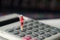 Figure miniature business woman or small people standing on calculator for money and financial business concept. Royalty Free Stock Photo