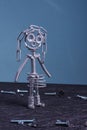 A figure of one small robot assembled from several bolts and nuts standing in a vertical position . It symbolizes technology, Royalty Free Stock Photo